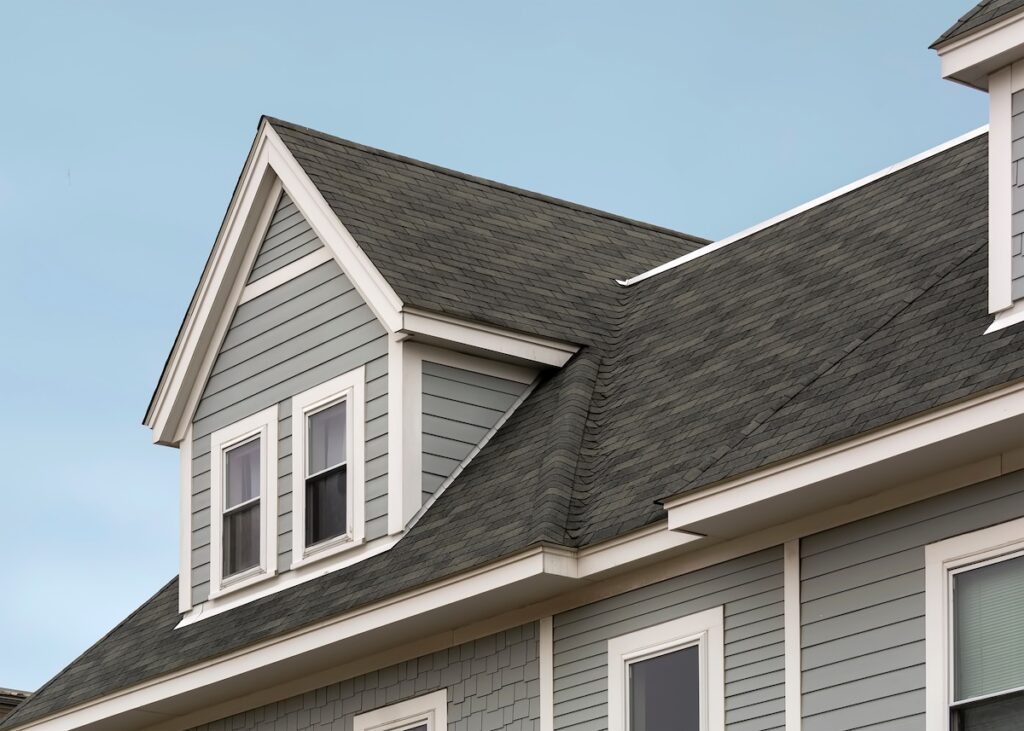 owens corning shingles Detailed view of a gable-style dormer window on a sloped roof of a newly built family house