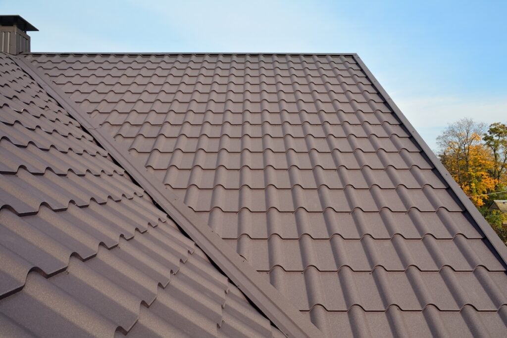 metal roof colors Metal Roof Construction Against Blue Sky. Roofing materials. Metal House roof. Closeup House Construction Building Materials. Roof construction. Coaxial Pipe Heating System House Coaxial Chimney Pipe.