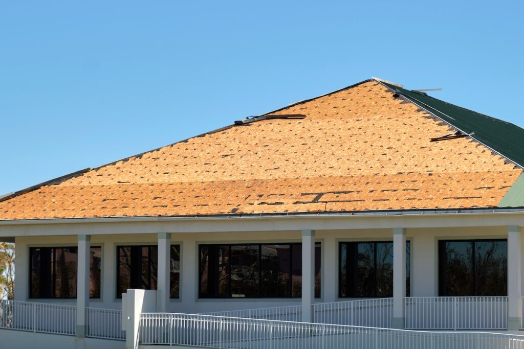 Damaged house roof with missing shingles after hurricane Ian in Florida. Consequences of natural disaster. average cost to tear off and replace roof