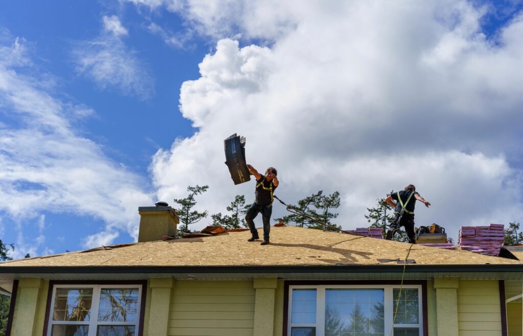 average cost to tear off and replace roof Roof workers tears off old shingles