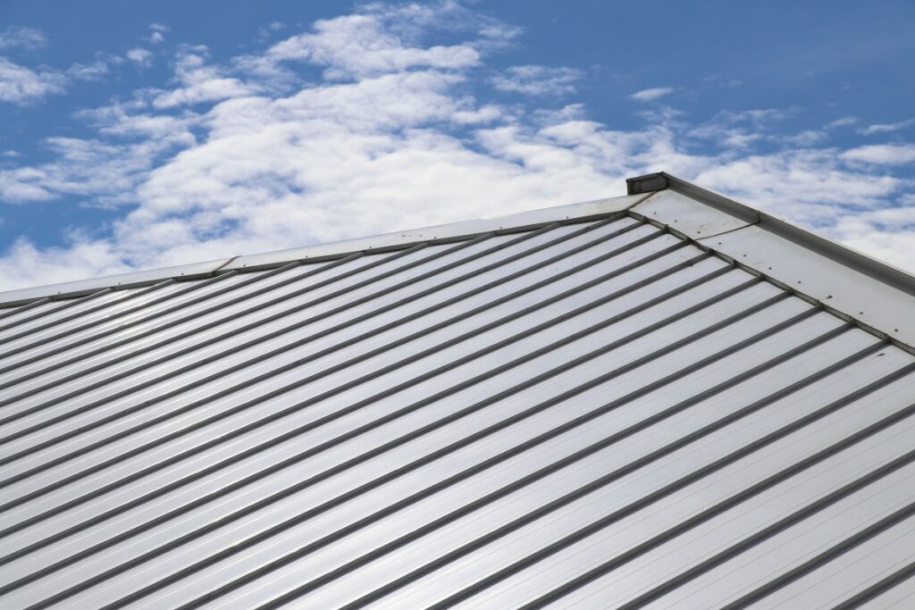 Metal sheet roof and slope with clouds and blue sky background