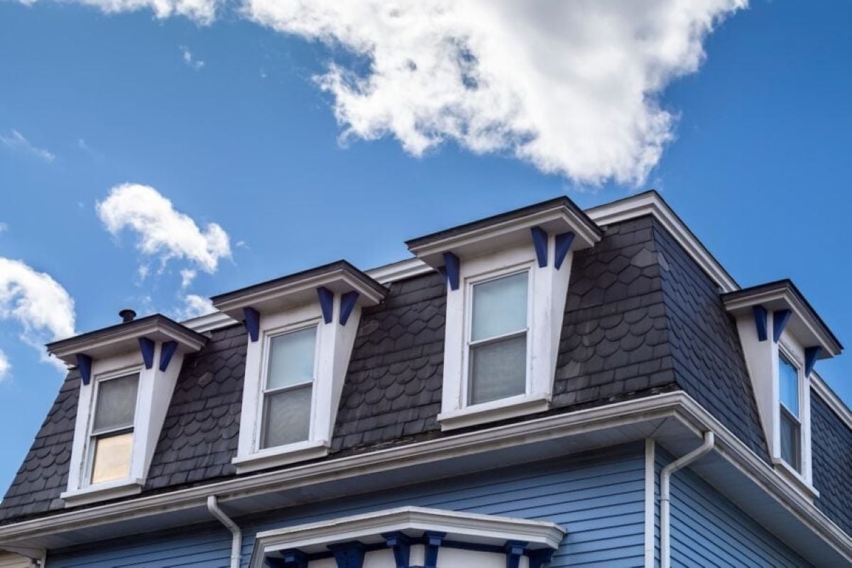 mansard roof big big blue and white house dark grey tiles blue sky
