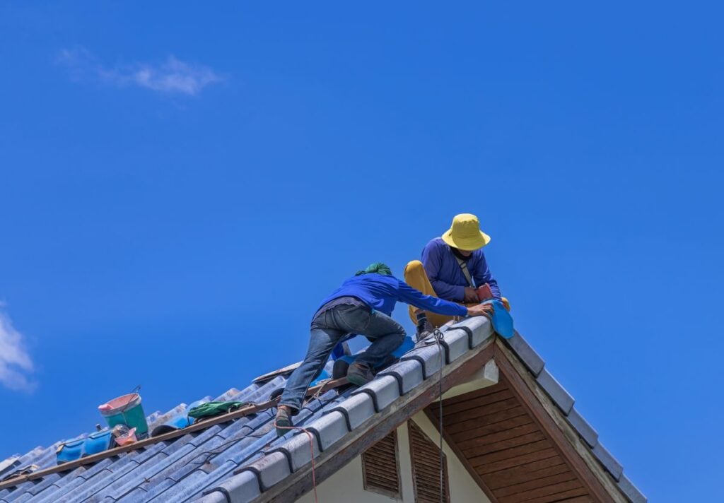 how long does it take to replace a roof workers replacing blue tiles