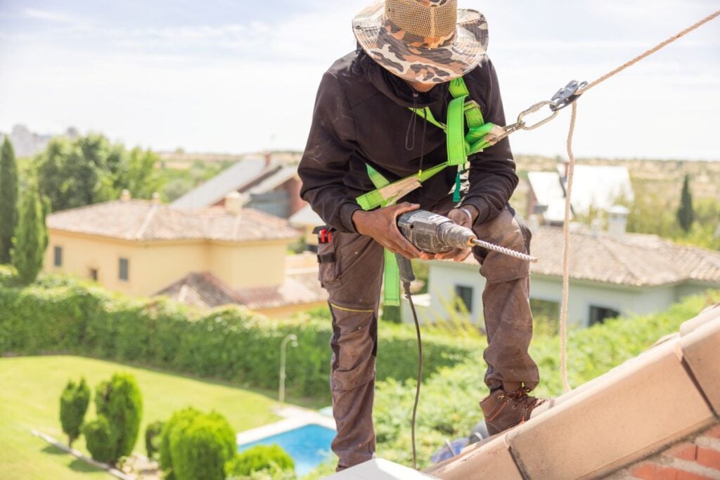 roof insurance claim worker installing new roof using security wires